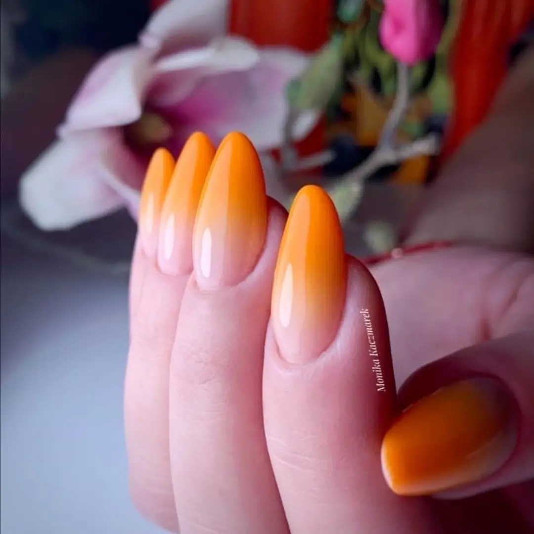 Oval orange ombré manicures such as this one will look amazing for the summer season.