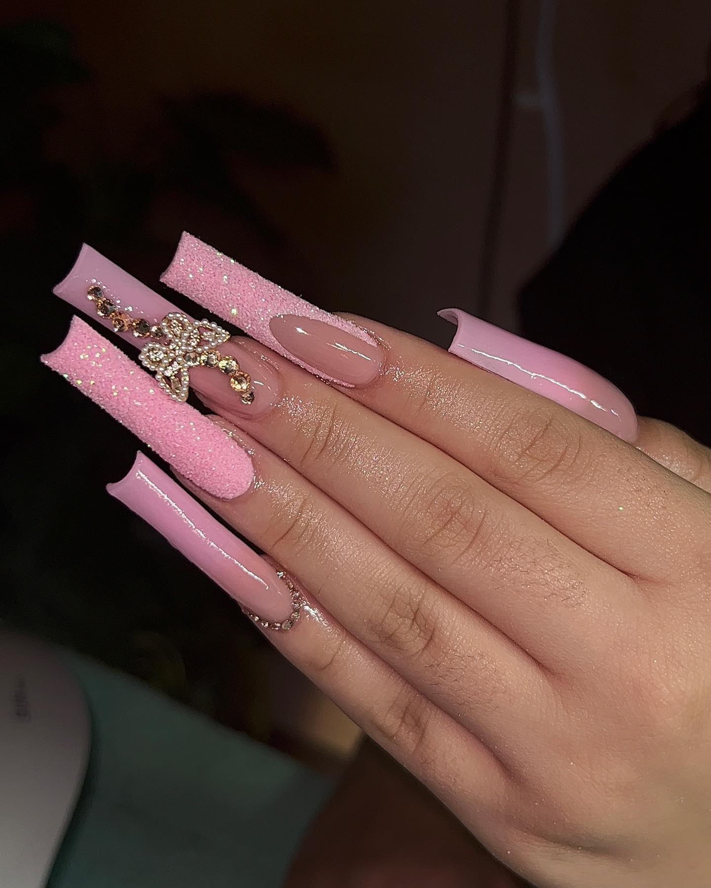 Acrylic pink nails and this extreme length will suit women who can handle the boldness of it all!