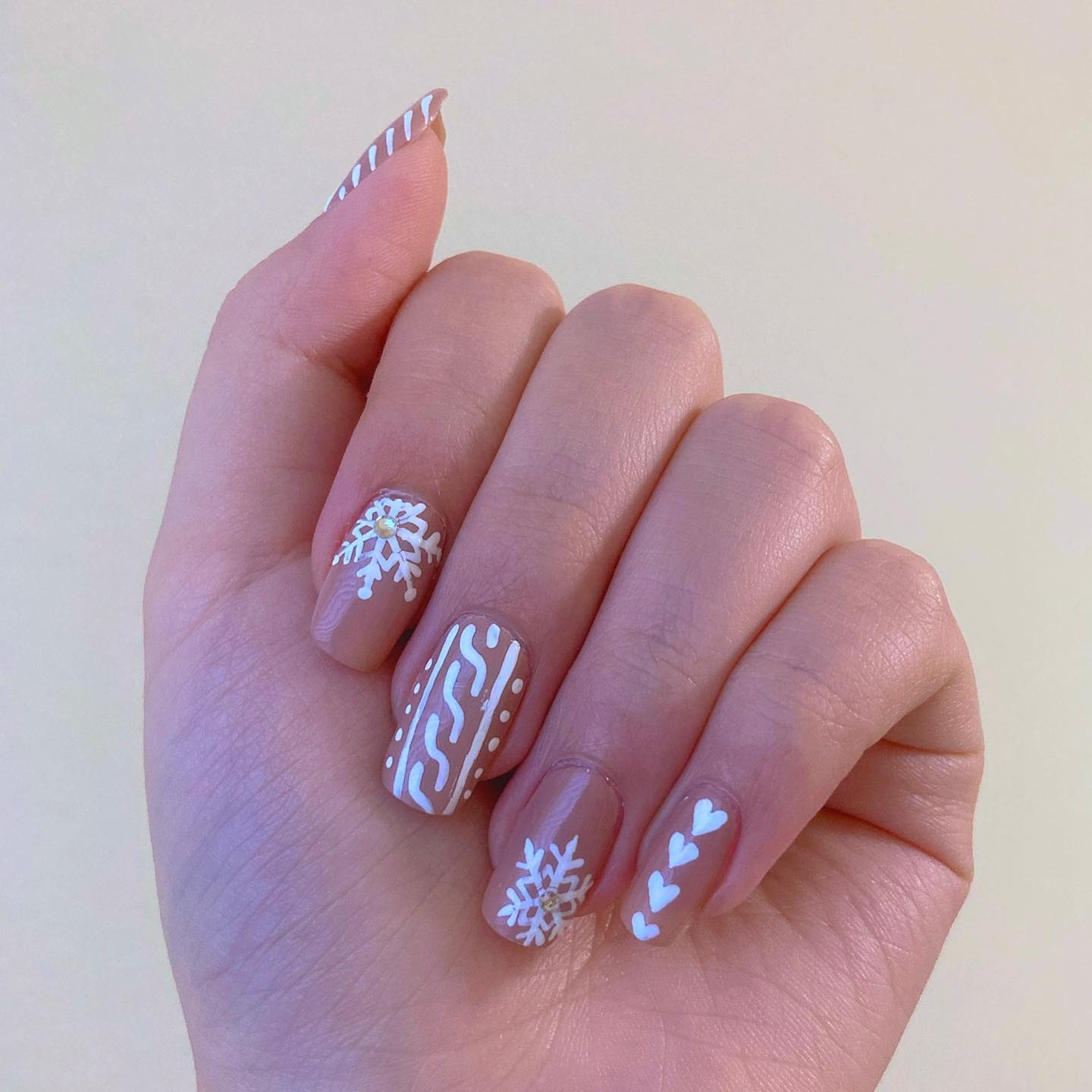 On top of your chic nude nails, why don't you draw some hearts, snowflakes and lines to give it a winter look?