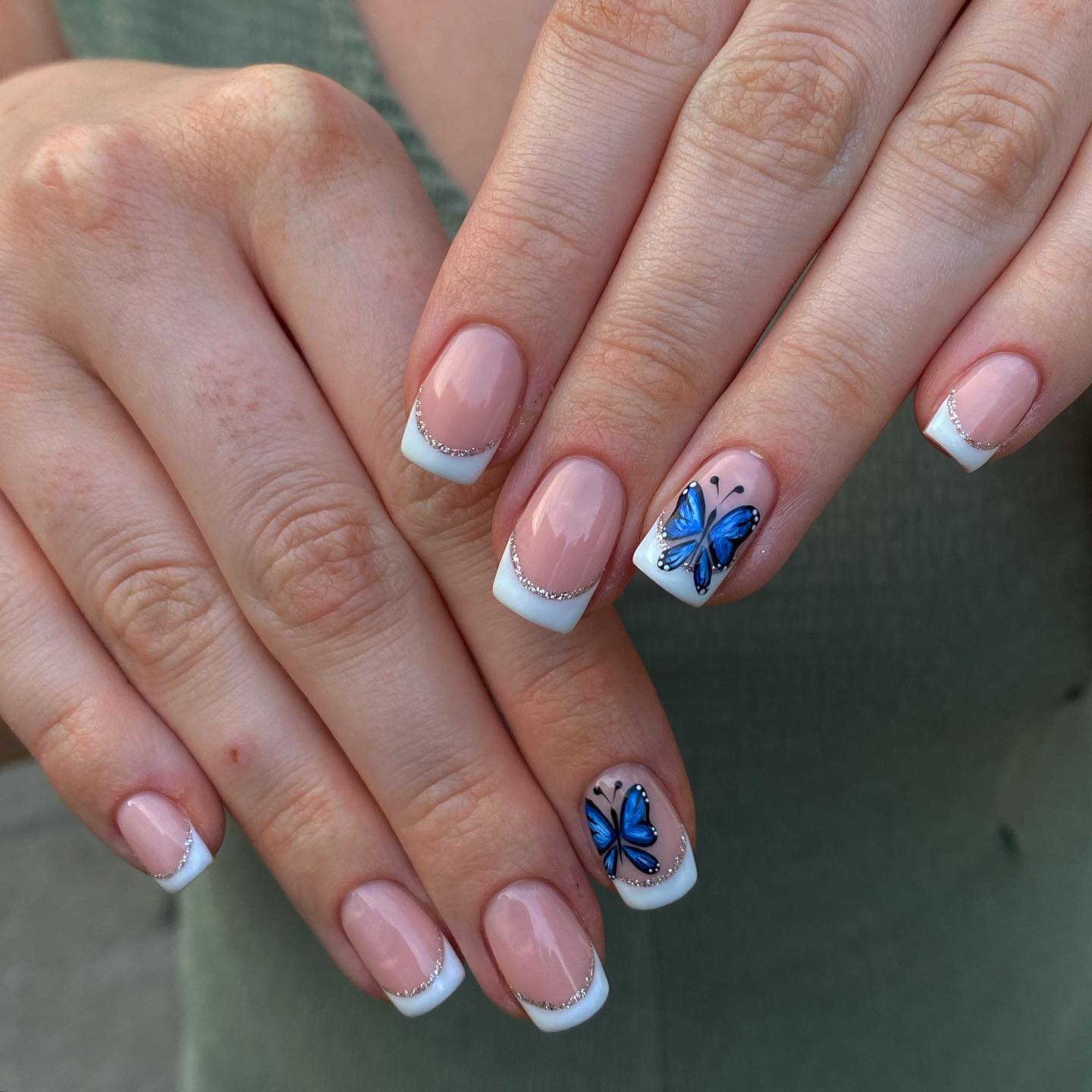 A french manicure with some silvery lines looks pretty. If there are two blue butterflies on it, it will be prettier.