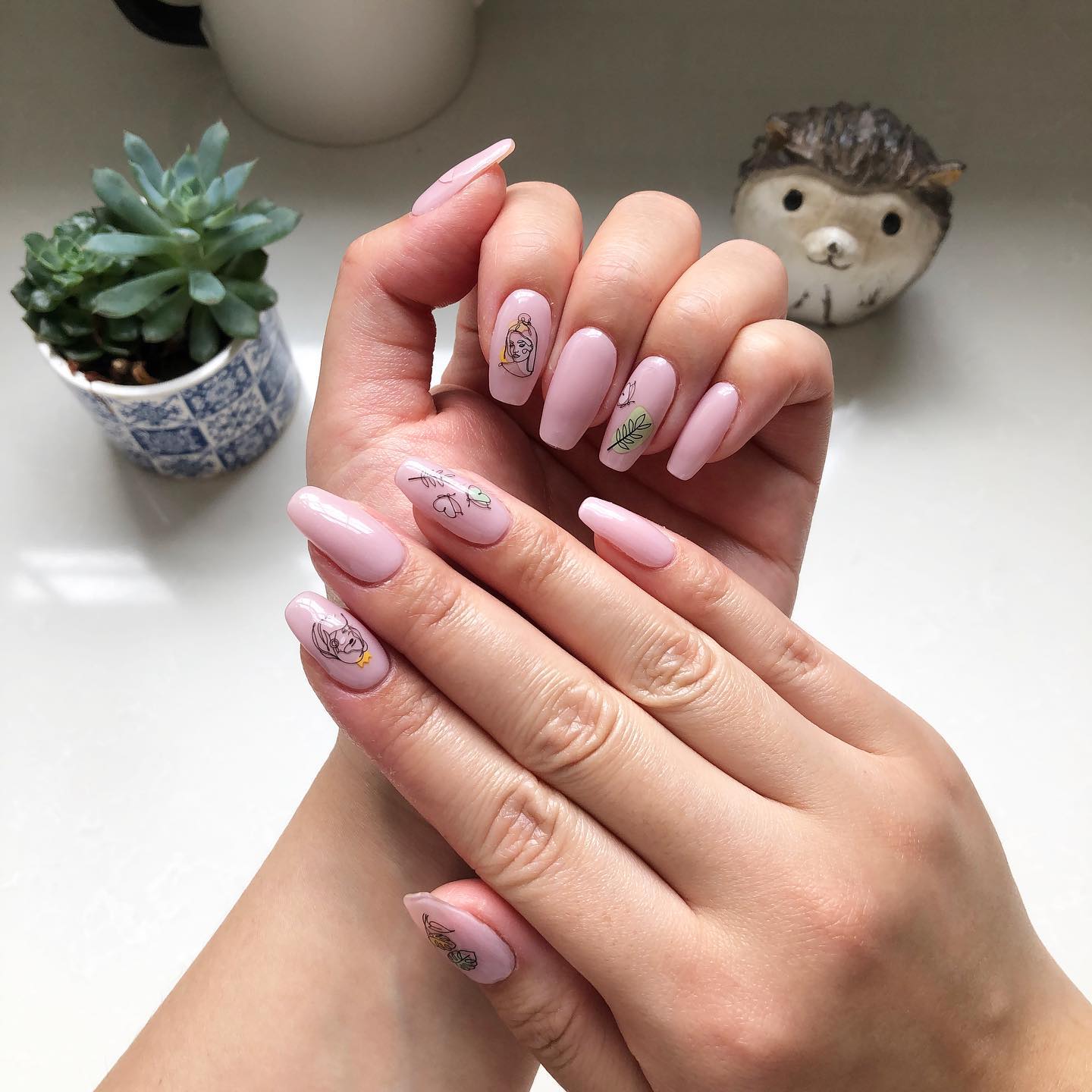 To achieve a simple and chic look, you can use some line art nail stickers on top of your light nude nails. These line art stickers can be woman portraits, leaves or butterflies.