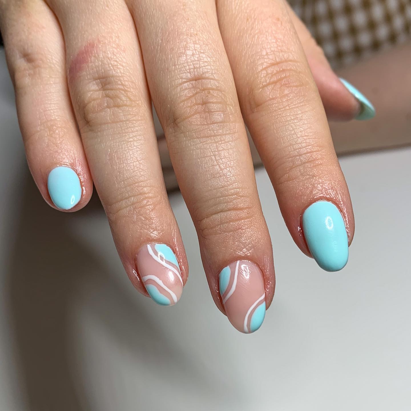 Here is another idea for light blue nail art. Two accent nails with some white lines and blue shapes are striking.