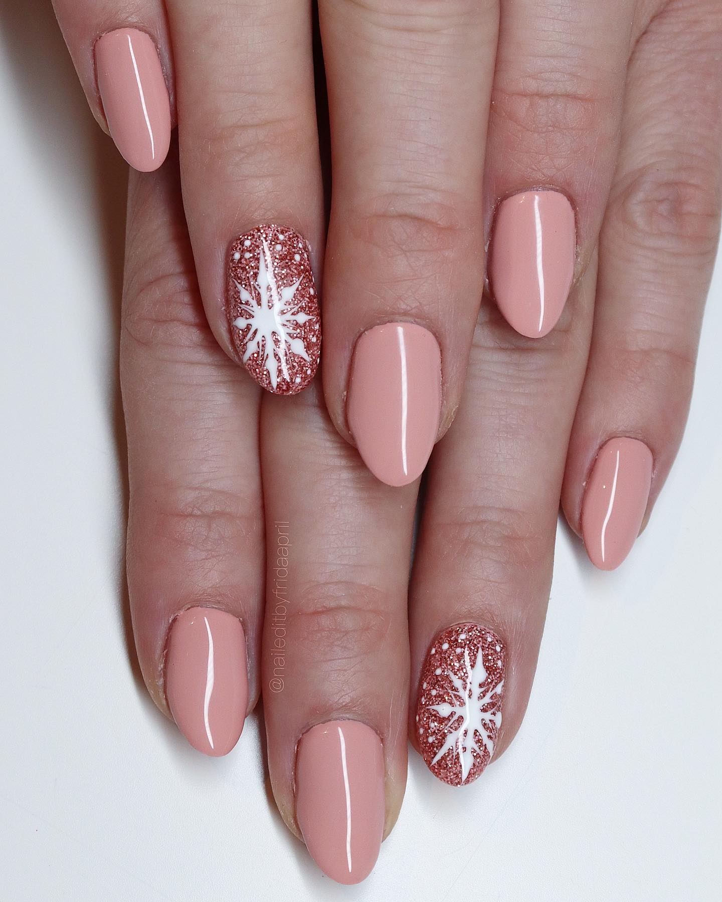 How to make nude almond nails have a winter look? As accent nails, a snowflake on glittered nails will look perfect.