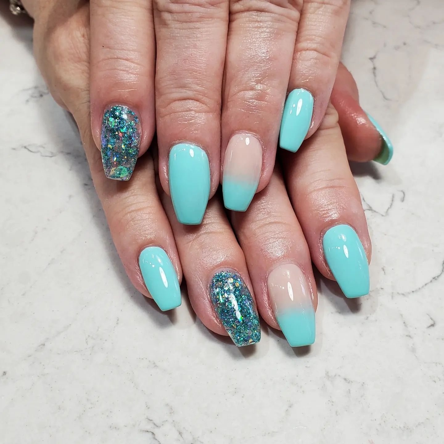 The beautiful color of the sea, turquois, looks perfect when combined with an ombre and glittered accent.