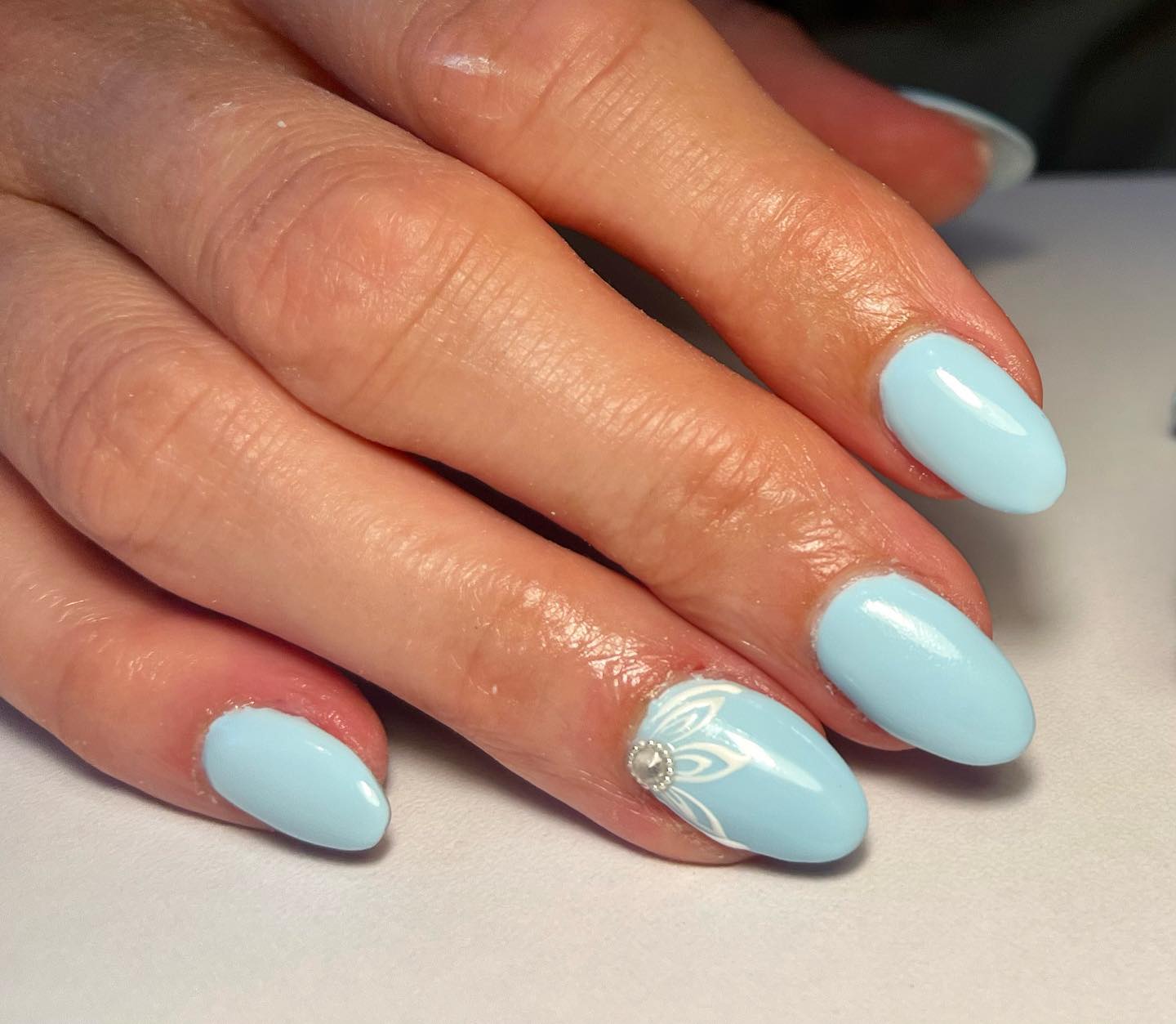 If you want to add some energy to your light blue nails, here is a nice one. When decorated with a flower and a stone in the middle of it, your ring finger will stand out.