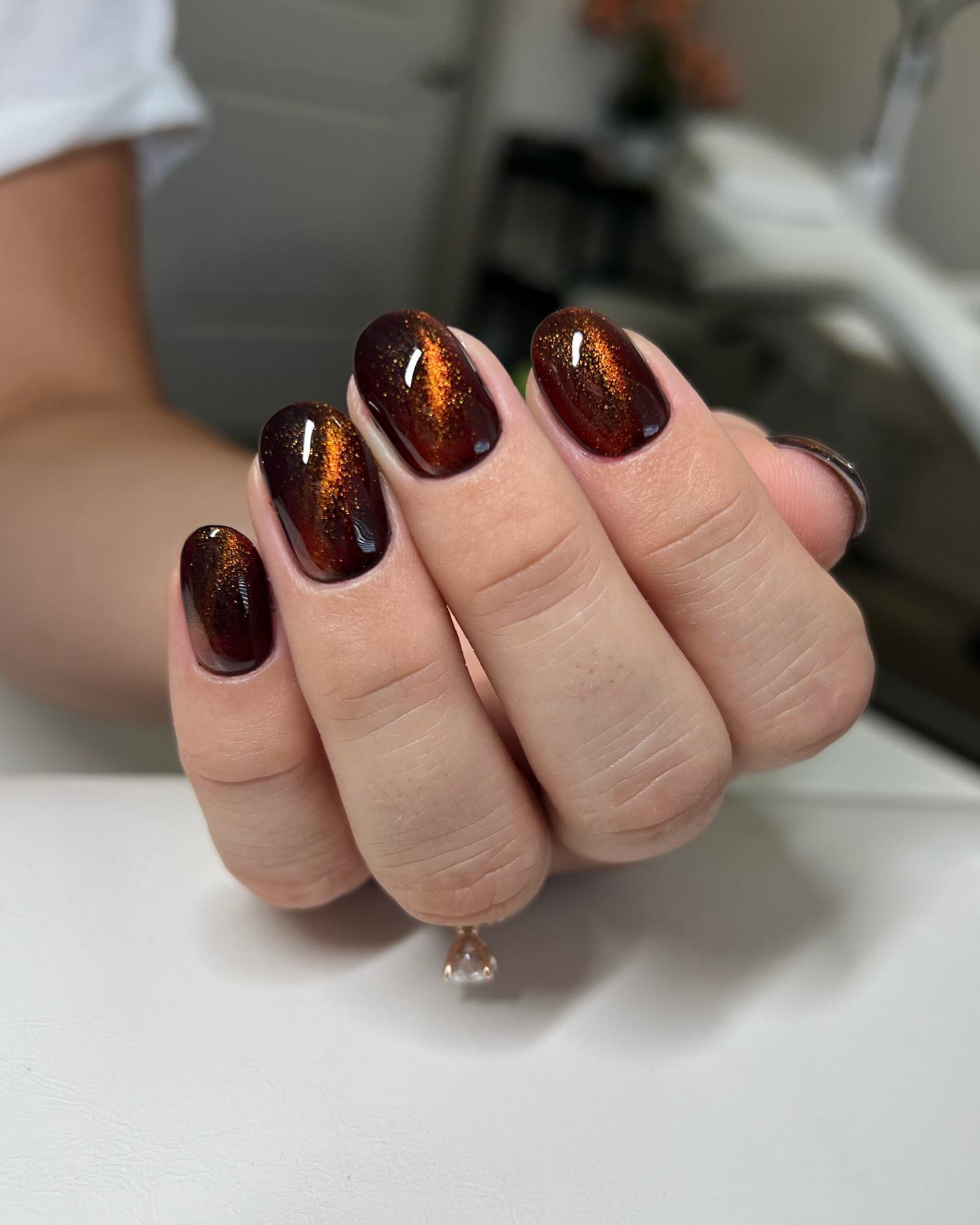 On a dark brown base, orange aurora cat eye design will shine out. If you want to stand out easily and look chic especially in Autumn, give it a shot.