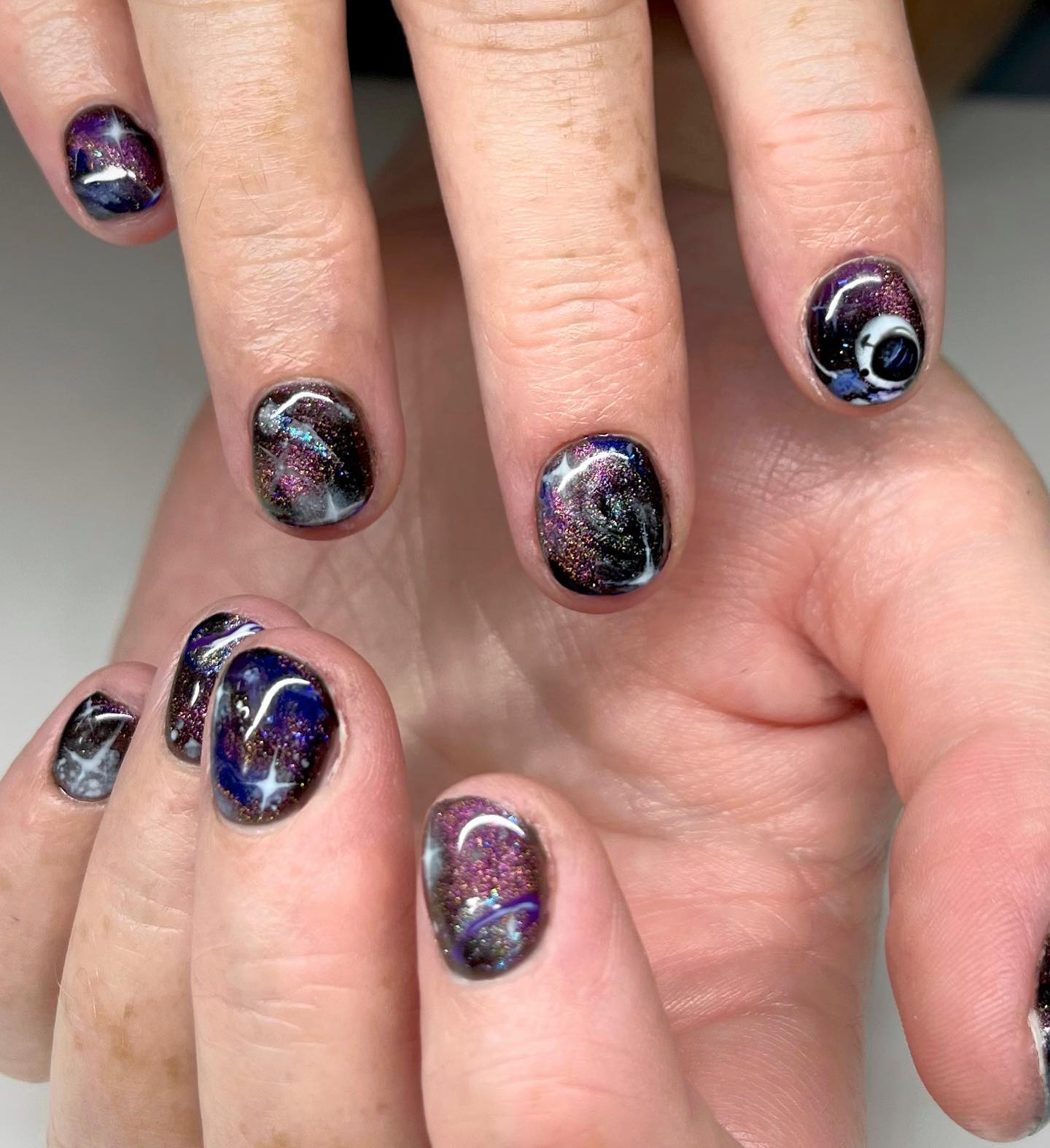 The space is full of galaxies, stars and mysteries. It amazes and inspires many people to design things with this look. So, why not applying a space cat eye nail design? You need to find a talented tattoo artist to get it.