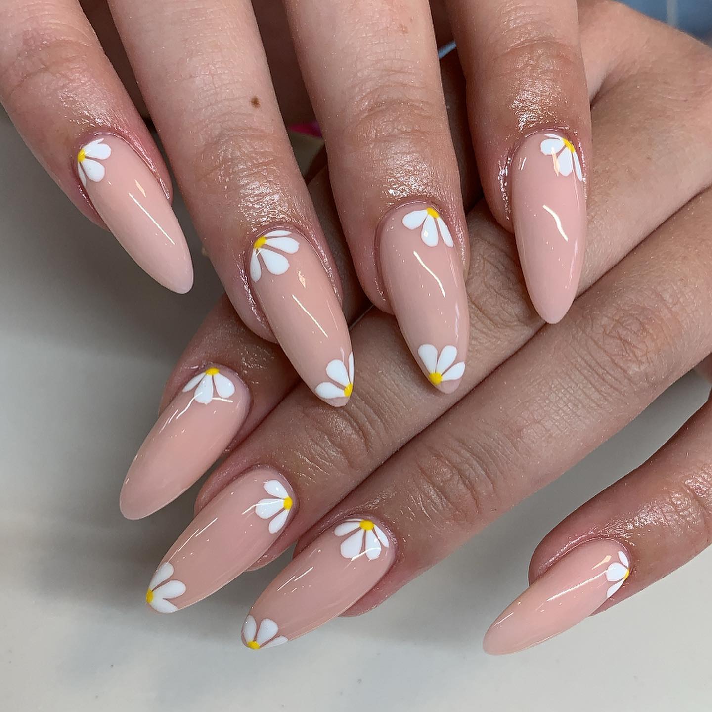 To try something new, why not having half daisy nails? White cute daisies will stand out on nude nails.