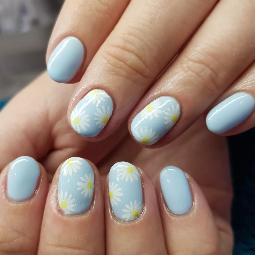 Light blue pastel with two daisy accent nails are so cute to wear. Your short nails will look beautiful.