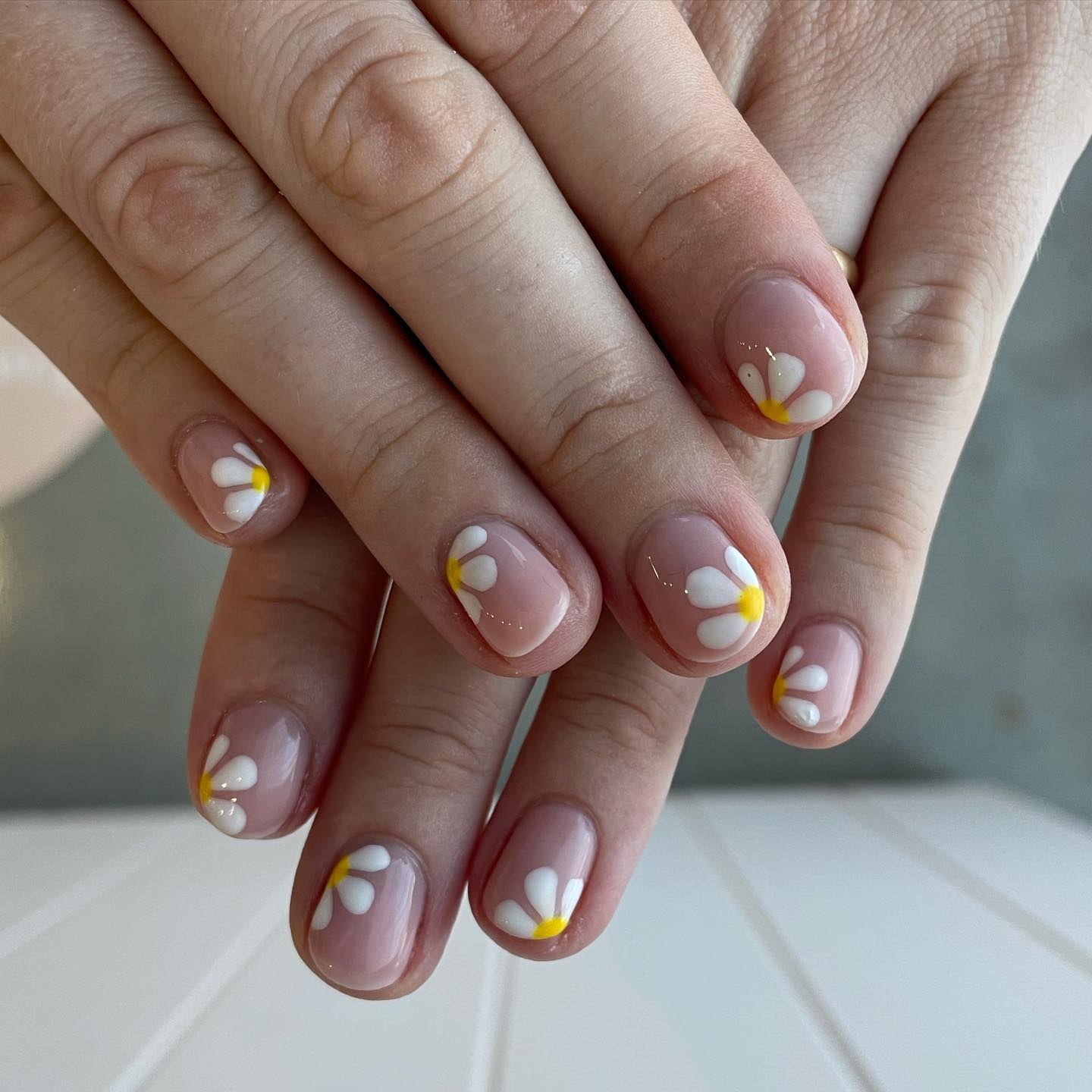 It's a pretty simple and chic nail design. All you need is to apply a nude nail polish to your nails and draw half daisies on them.