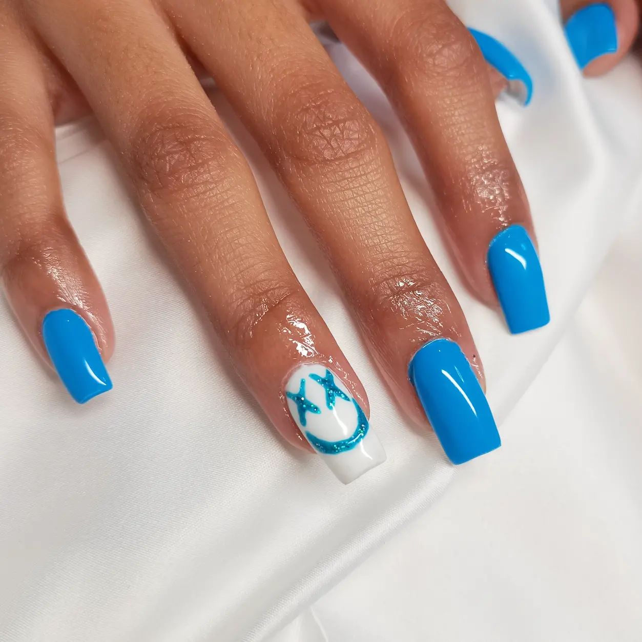 This neon blue is quite electric! A smiley face with a glittered blue nail polish is nice nail design to try.