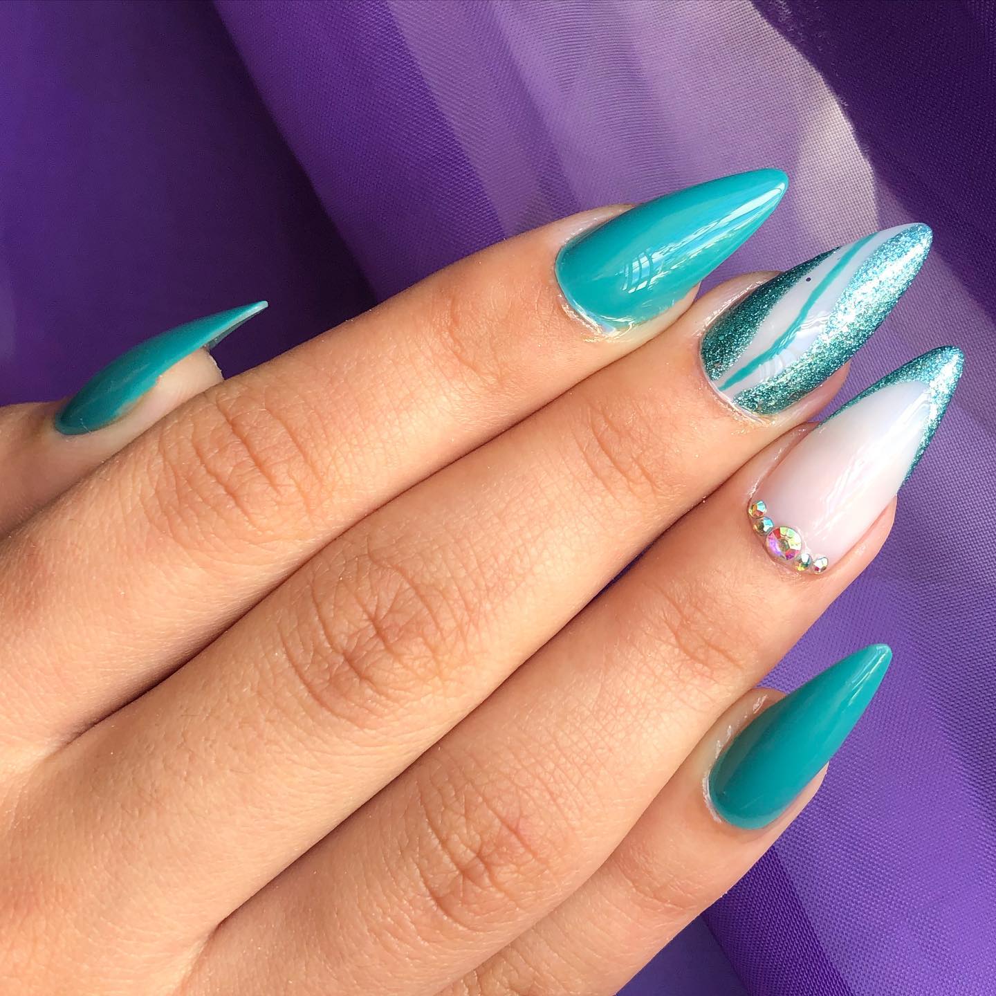 It's between green and blue color, isn't it? If you like this shade of green, you should definitely use it with these swirl and stone nail arts.