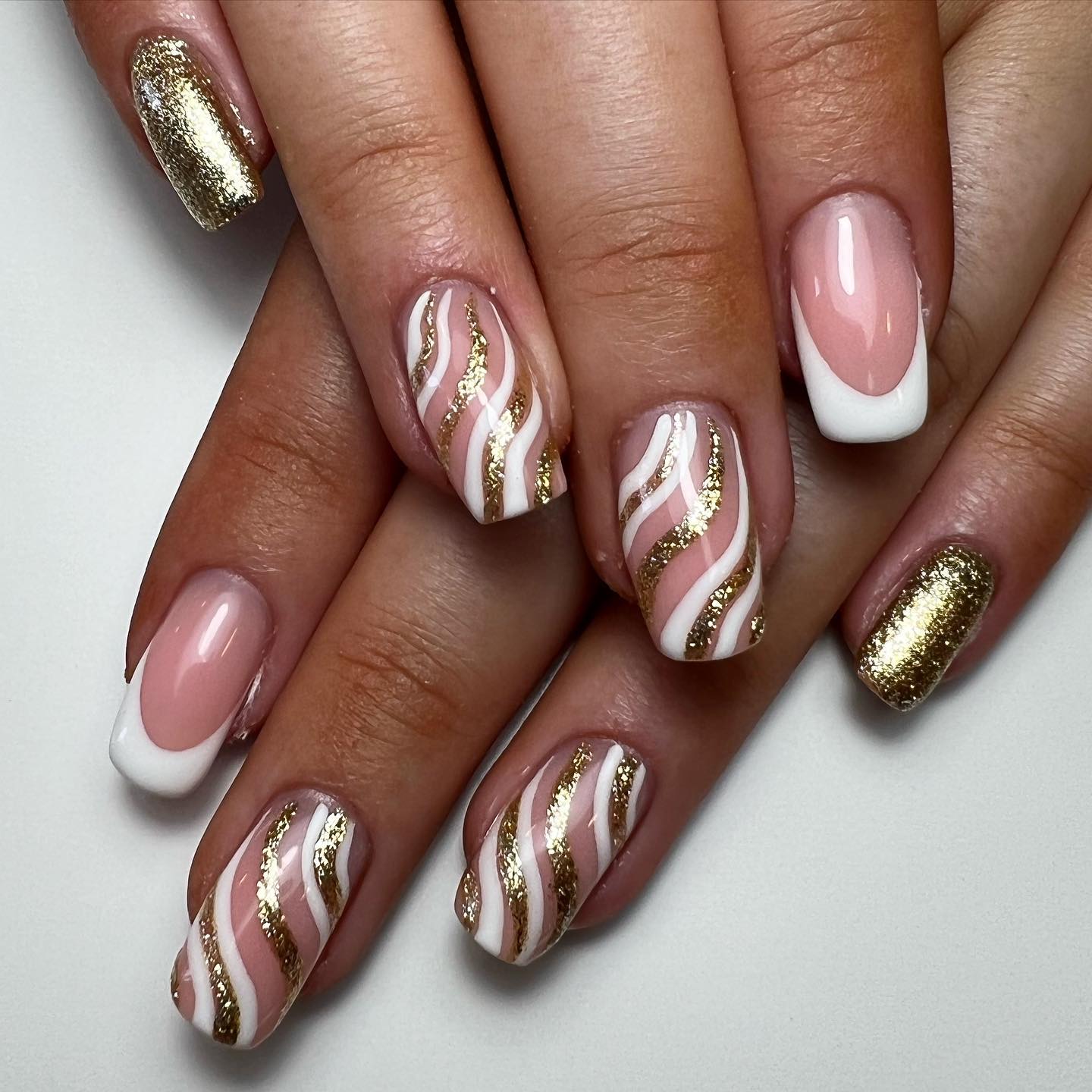 If you are a person who likes too much of everything, a detailed swirl nail art is for you. These white and gold glitter dense swirls will be enough to show your characteristics to everyone.