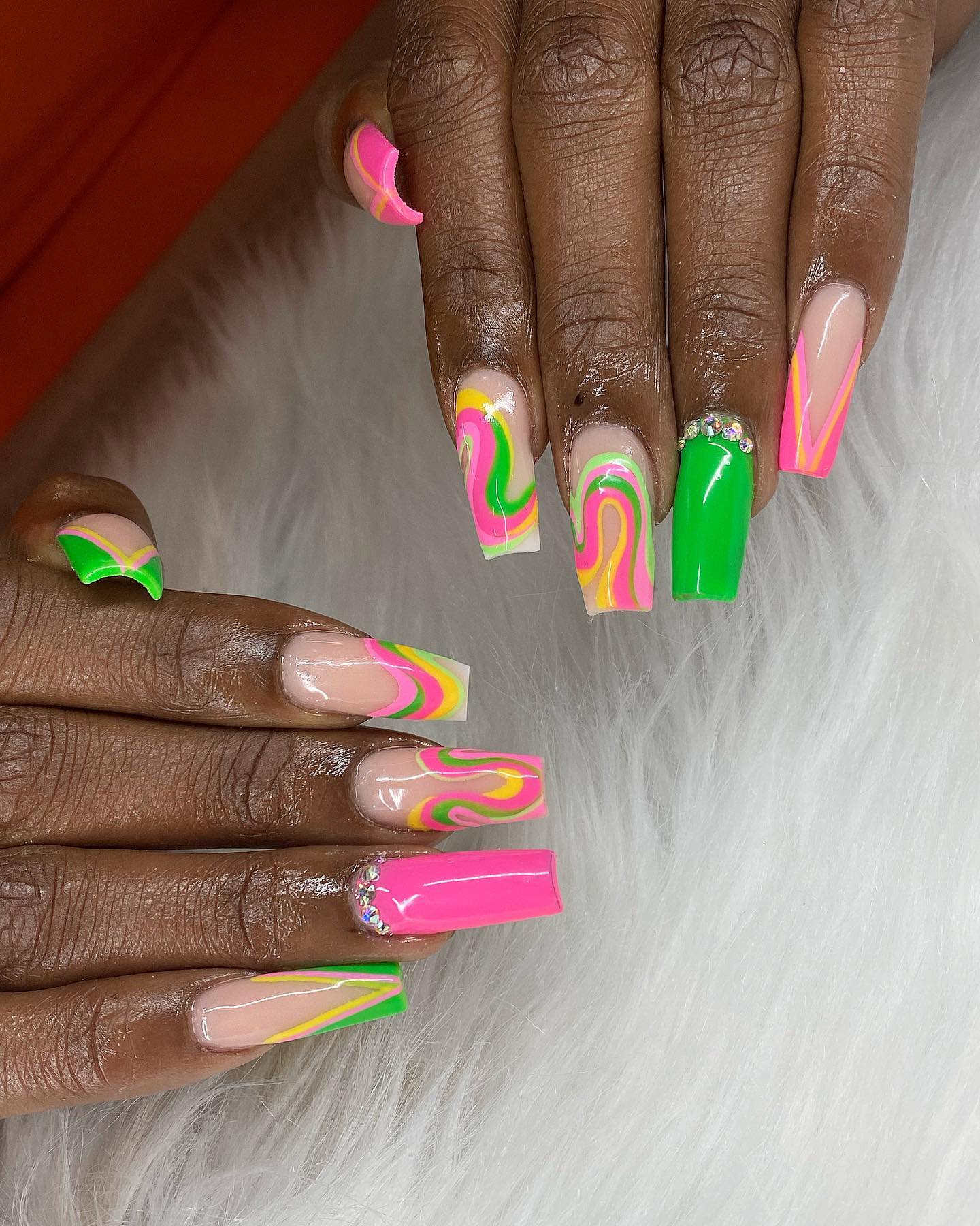 Pink, green and a little bit of yellow color are insanely perfect to combine with each other. All of these swirls, stones and accent nails will make you look amazing.