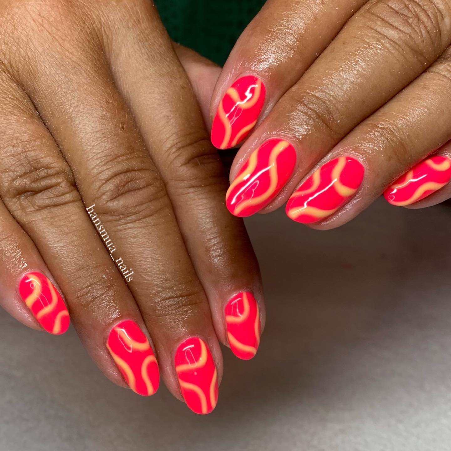 On a bright pink nail polish, what is the best thing to do? Wearing some random swirls! Light orange color will go with these pink nails.
