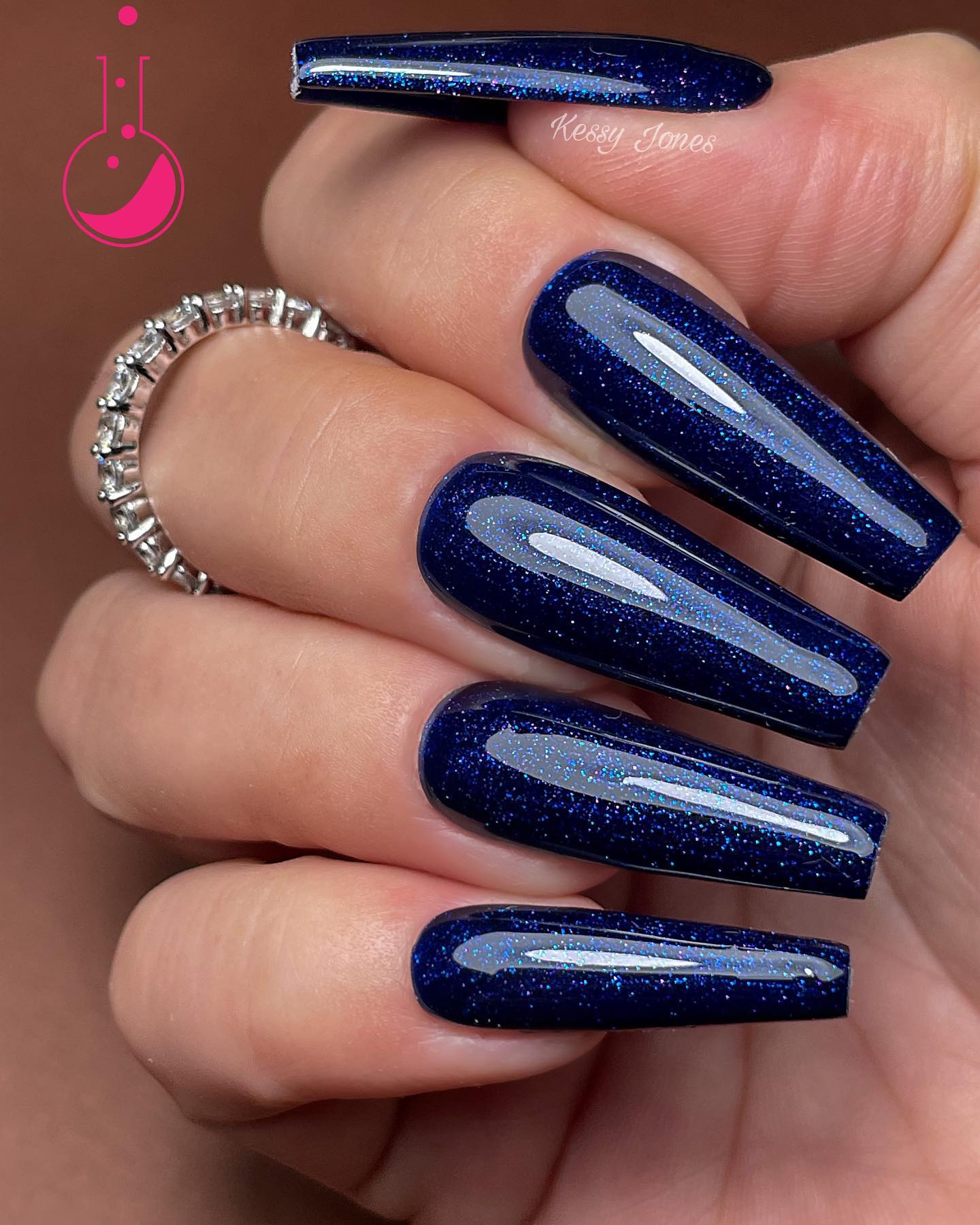 Glittered nails are a great way to express yourself. Navy blue is a really cool color, and the glitter adds some fun to it. The glitter is also a great way to show off your personality, and it's fun for people who like shiny things.
