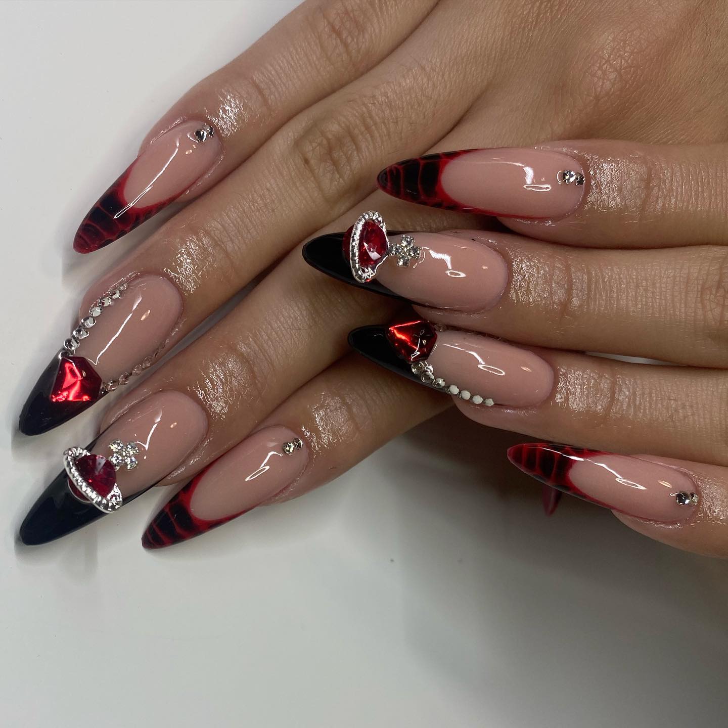 No words are enough to describe this gorgeous look. For two accent nails, black and red French tips are created with a snake skin look while the other ones are decorated with stones and rubies. It is absolutely incredible!