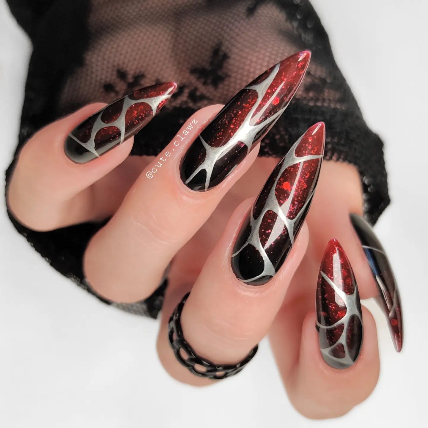 It is so cool! These nails give a bit dark spiderman vibes with the dark red and the weblike silver. The glitters behind are adorable, too. You have to go for it.