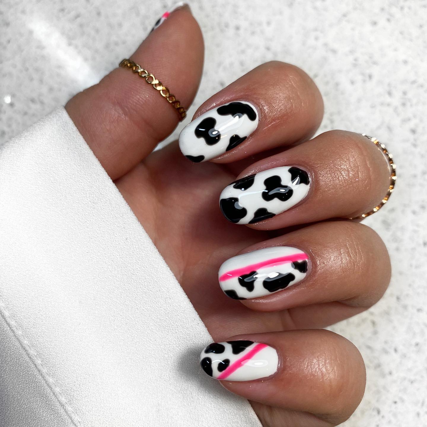 Almond cow print nails are a great way to add some dimension to your look. Plus, as for your accent nails, a pink line that separates cow prints and white nail polish. So, if you want to try something new but not too crazy, go for it.