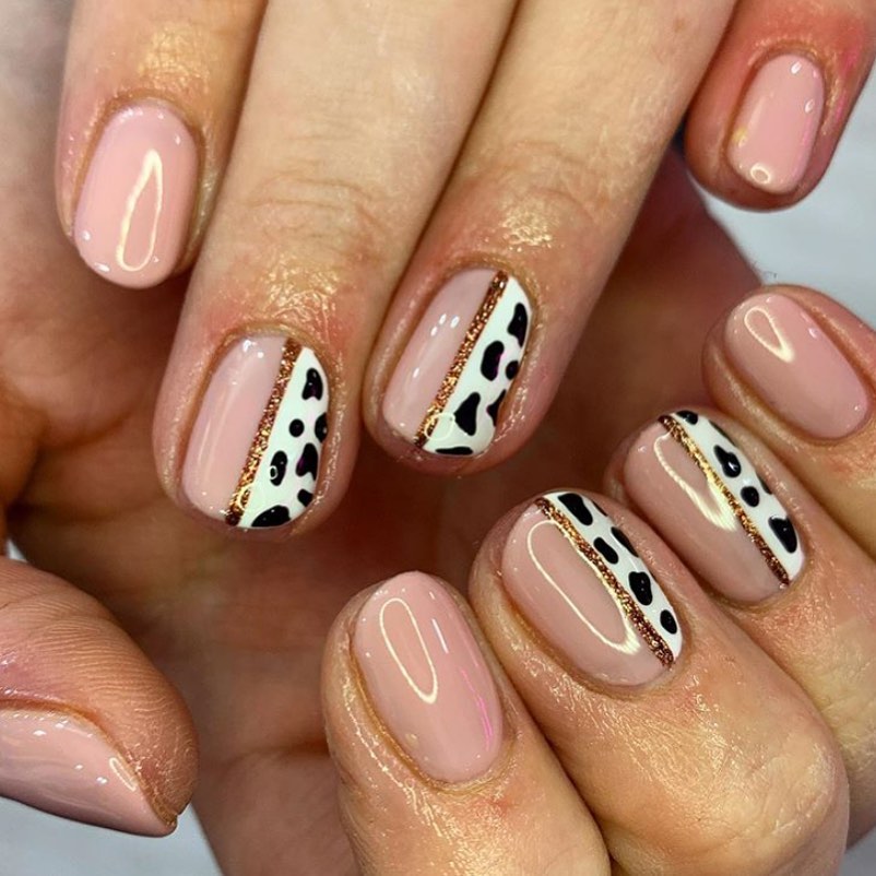 If you don't want a dramatic change on your nails but still want to try cow print nail art, this nail idea is for you! The nude nail polish will help you keep the look simple, while the black and white cow print adds a fun twist.