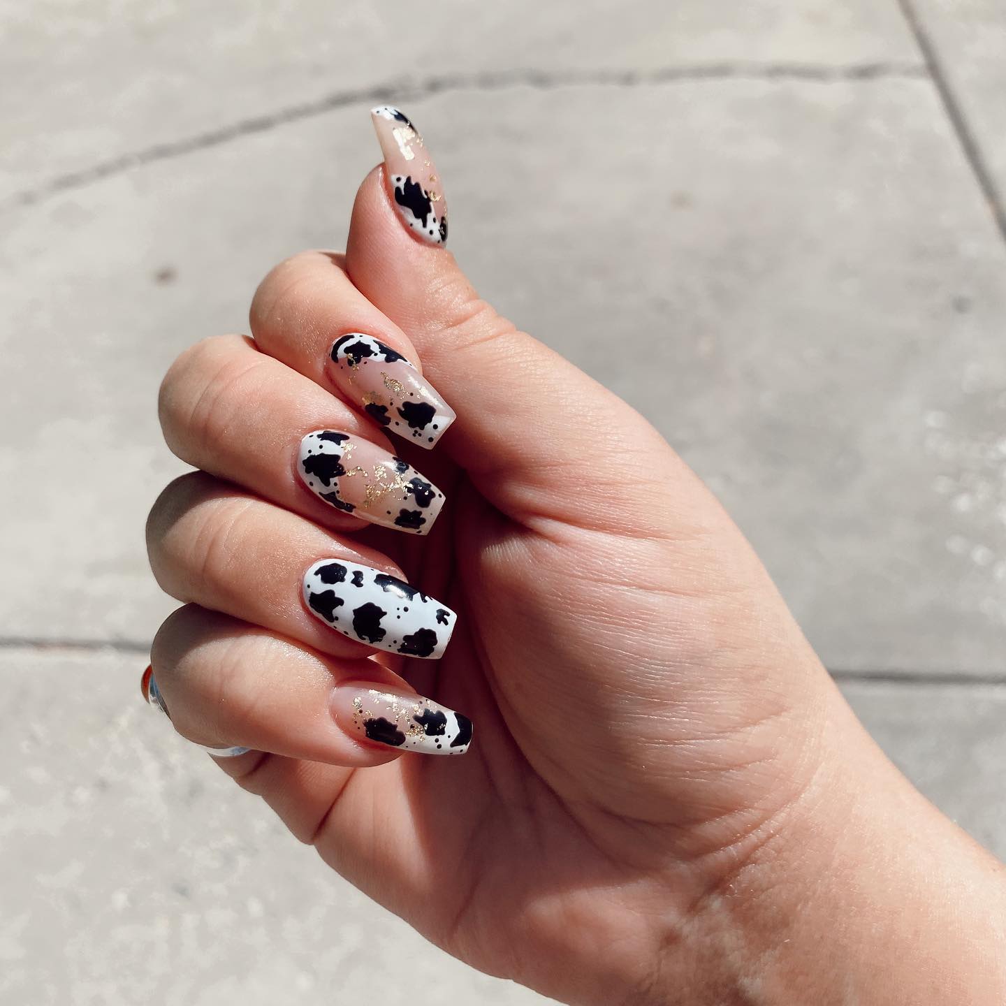 Go for a cow print nail art that is combined with nude nail polish to rock. In order to show off your personality, why don't you add some golden glitters on top of them?