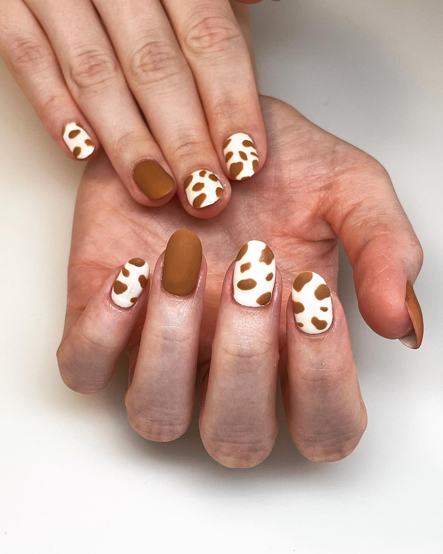 Representing simplicity and steadfastness, brown is such an elegant color that all of its shades are perfect for nail designs. Plus, applying this color with a cow print nail art sounds much more fun!