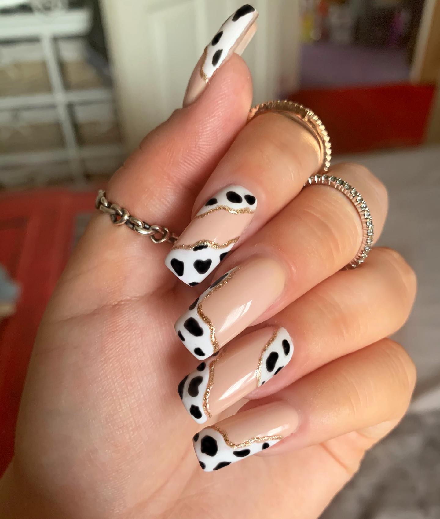 Matching swirl nail art with a cow print is a nice way to show your great taste to everyone! As a base, use a nude nail polish and draw a swirl with glitters to separate cow prints. It is absolutely amazing!