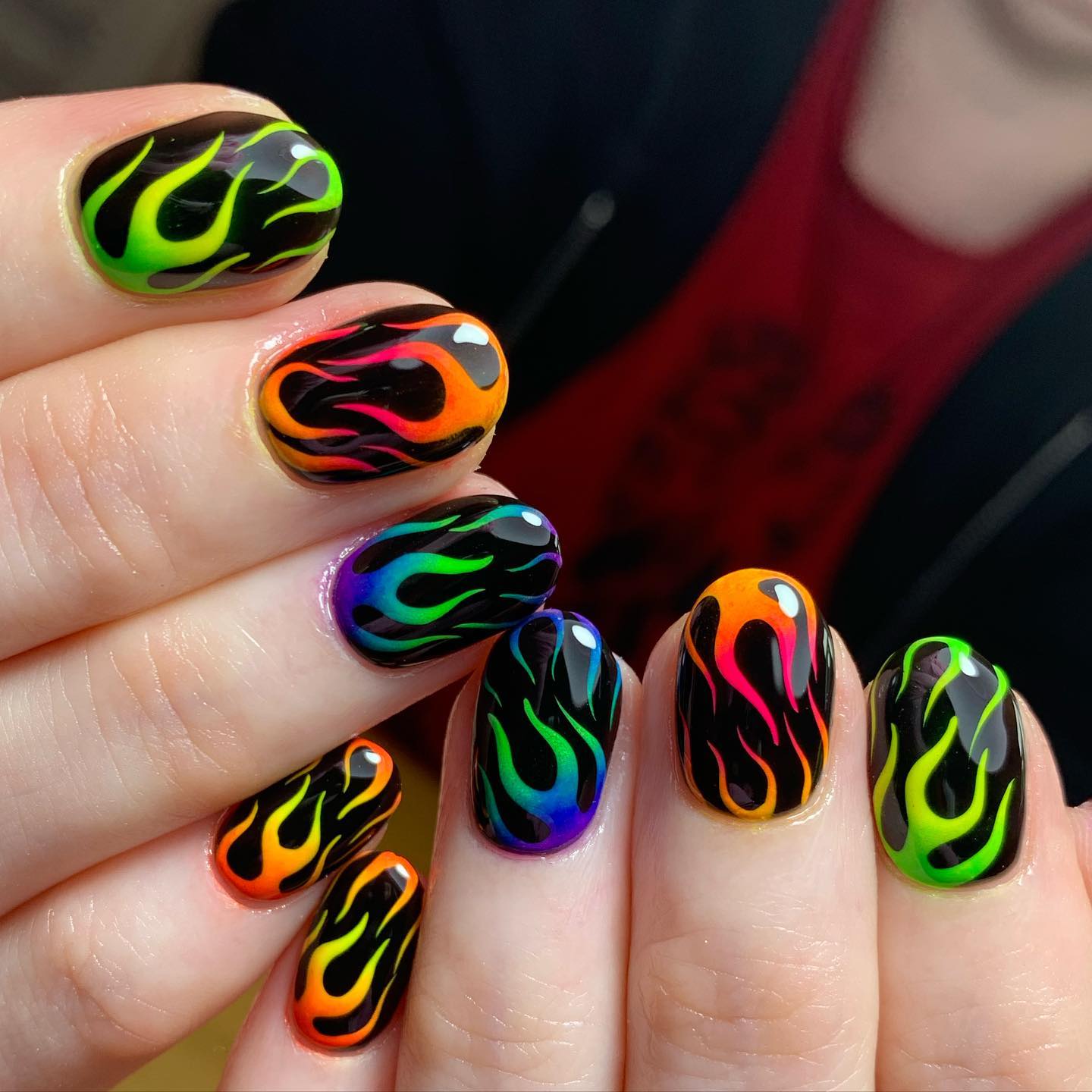What's the best way to make neon flames stand out more on your nails? The answer is applying a black nail polish as a base. Flames of varied neon colors are quite eye-catching, so everyone will notice your nails.