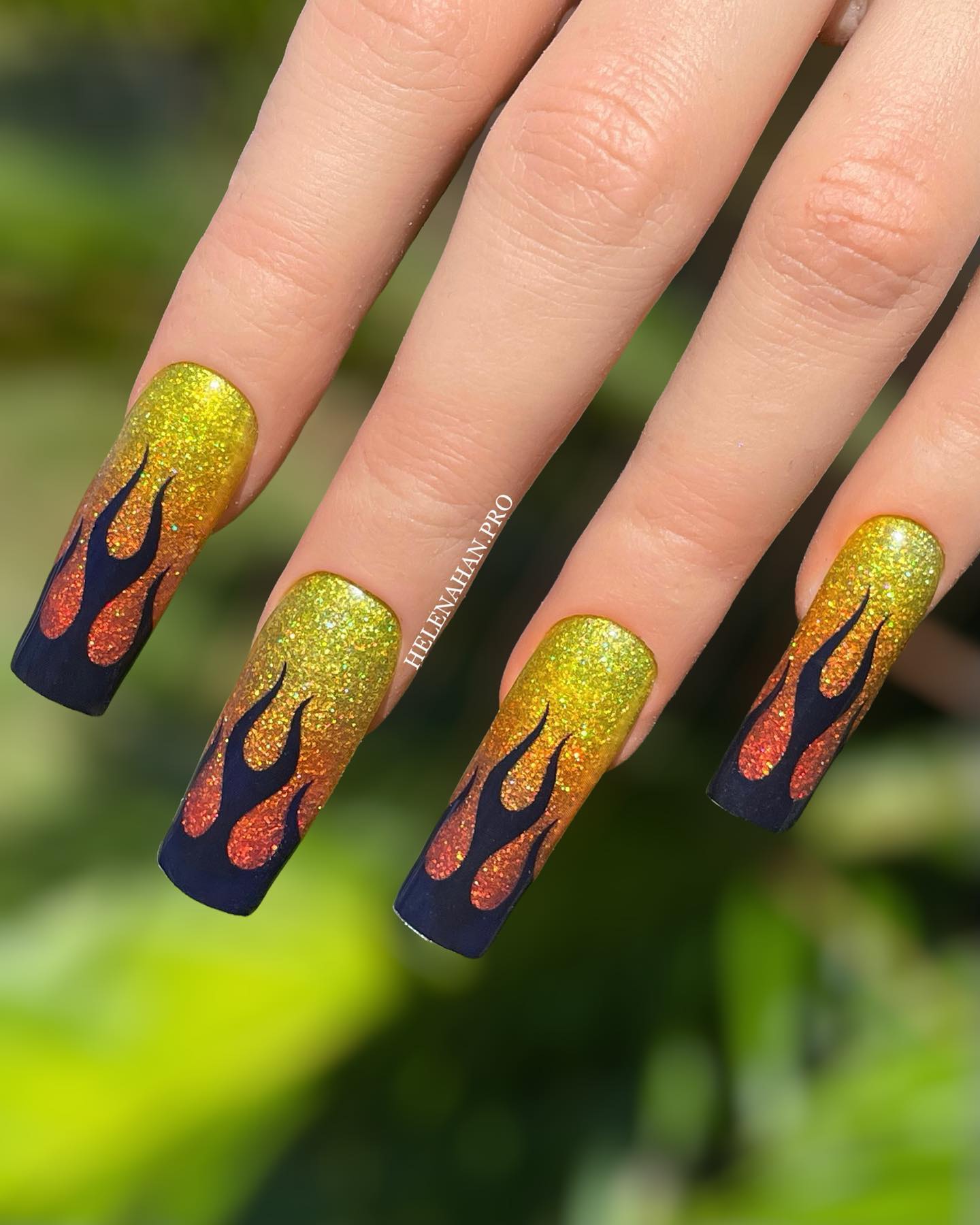 Holographic nails scatters the light in a way that it creates a special light effect. Are you ready to shine out with your long and shiny flame nail art? The color combo of yellow and orange is matching with black flames.