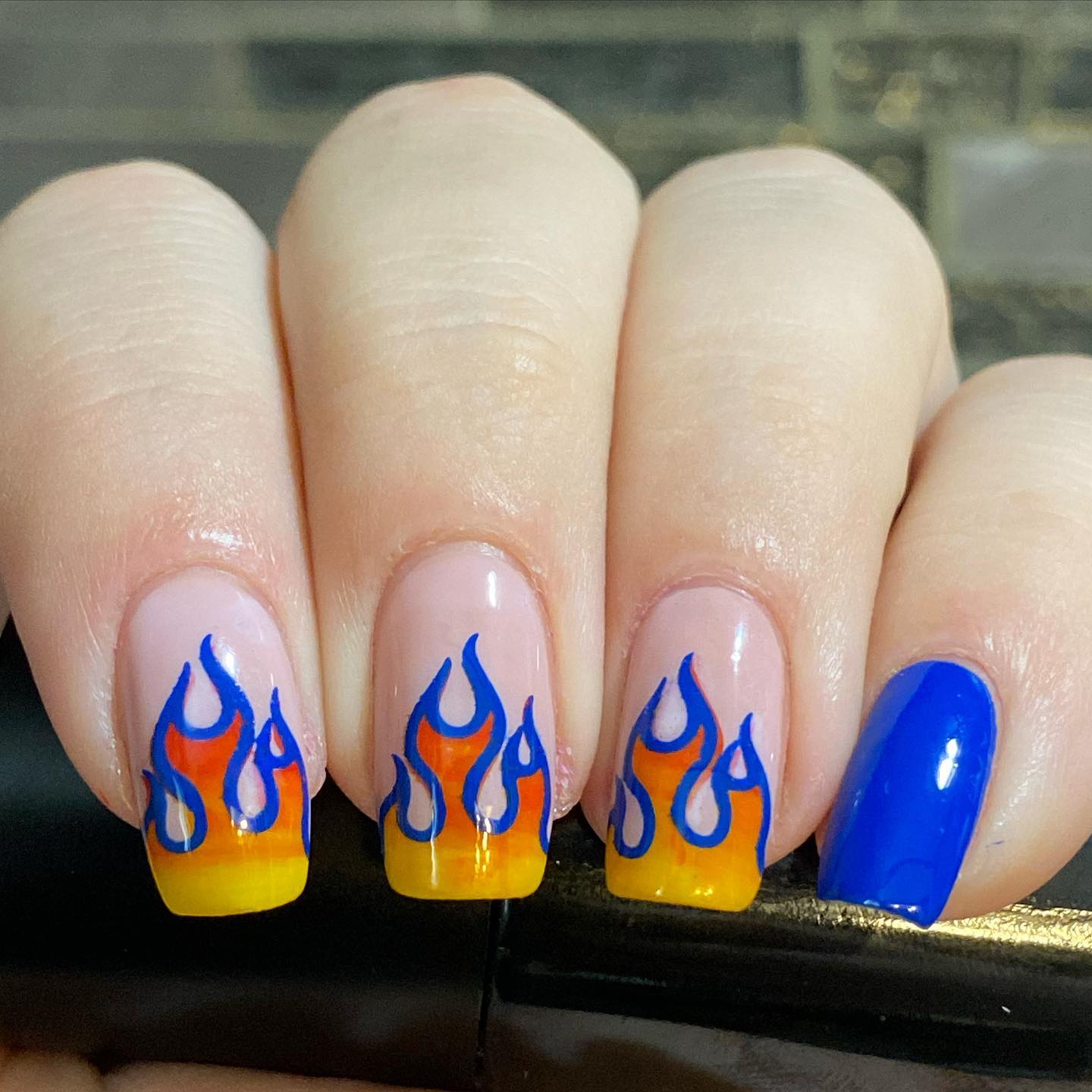 Red, orange and yellow colors are the colors of a flame but why don't you make them stand out more on your nails? If you want to do it, all you need to do is cover your flames with a dark blue nail polish.