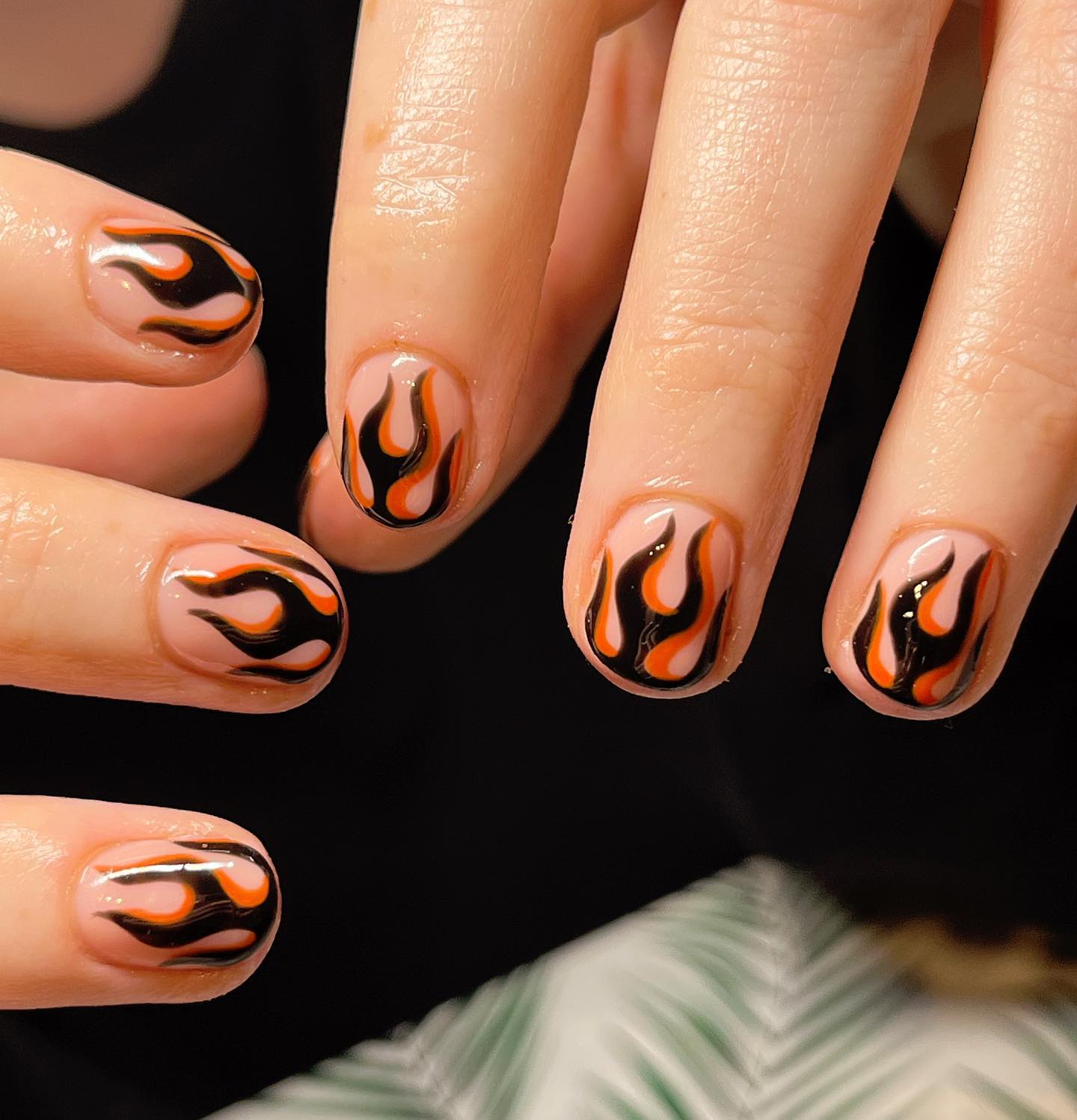 Short nails are simple as well as nude ones. Wanna cheer up your nails with something unique? Then, let's cover your nails with flames that are painted with black and orange.