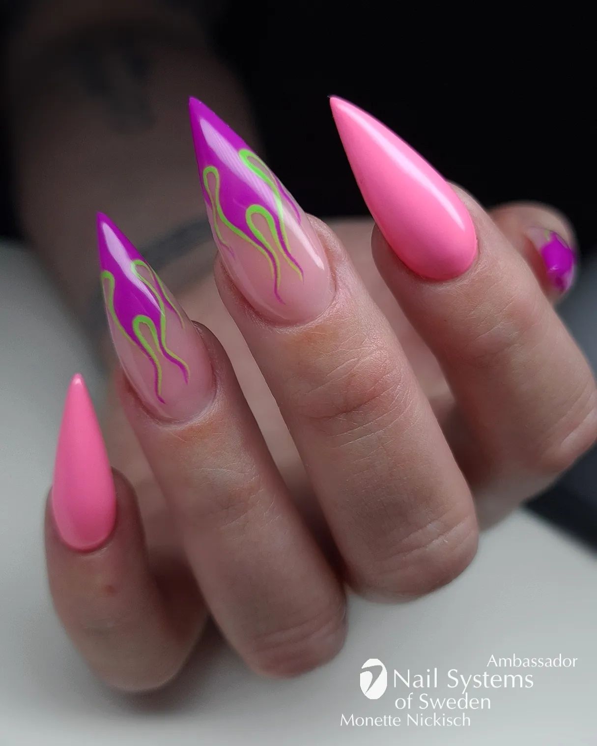 Do you fancy the combination of pink and purple? If yes, this nail art idea is a one to adore. Apply pink nail polish to two of your nails and draw purple flames with green edges. This is all you need to shine.