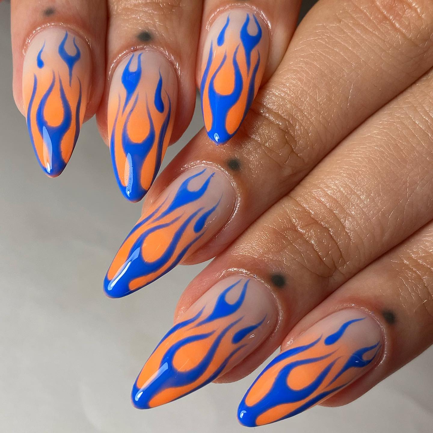 Orange and blue colors are quite striking that it is almost impossible to miss them out. On your nude and plain nails, this color combo of flame nail art will shine like stars. It's time to get them!