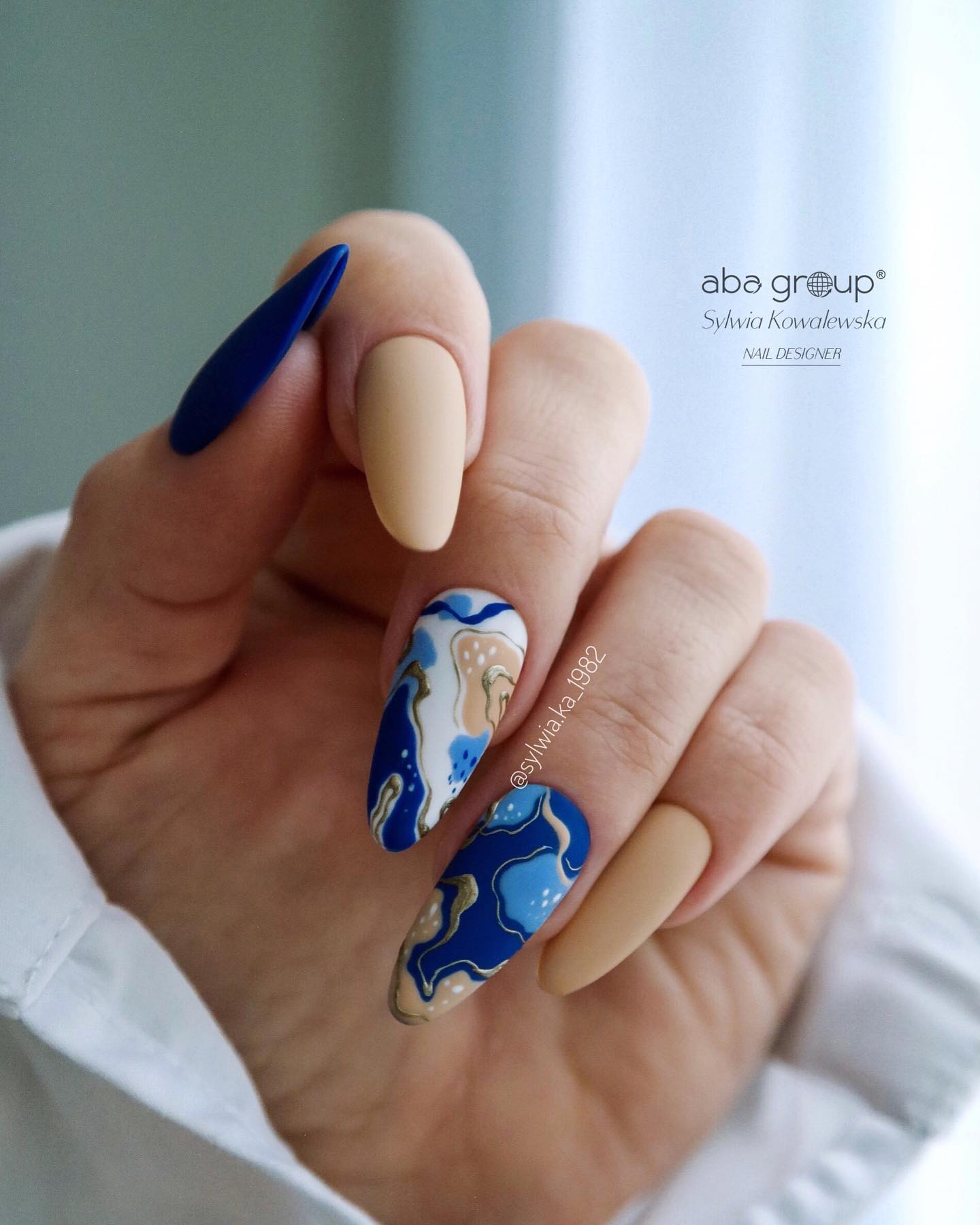 Abstract nail designs are bolder than other designs because of their creative art. They are customizable according to your mood. The matte nails above feature a great color combo of beige and dark blue with abstract nails which are decorated with abstract art.