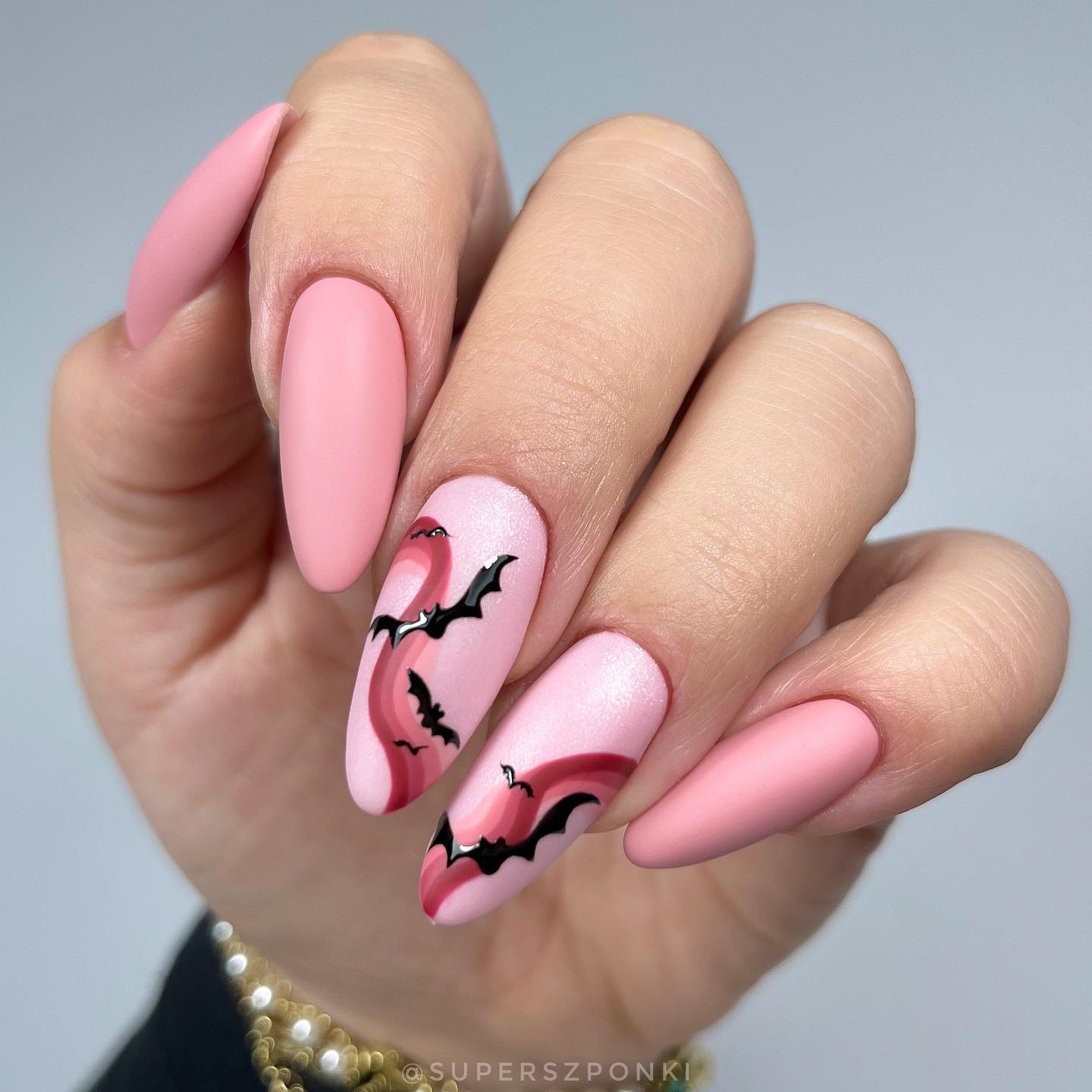 Bats are dark animals and most people are scared of them but in this nail design, two opposing colors which are soft pink and black are combined to create contrast. Accent nails with a pink swirl nail art look amazing with flying bats.