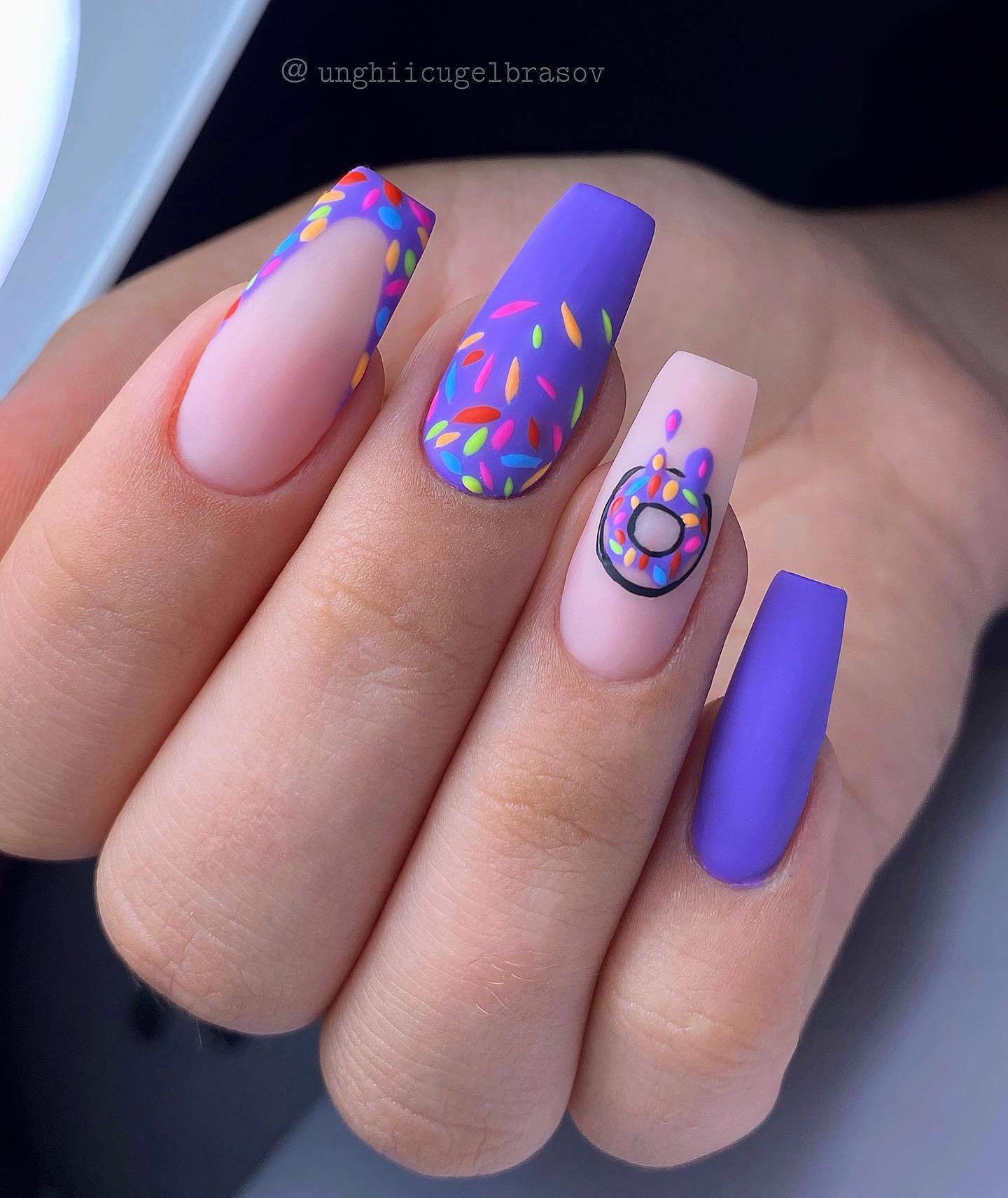 All shades of purple are amazing but the neon one is the greatest. In this nail design, accent nails are decorated with a purple French manicure and a donut, which is everyone's favorite. Also, these tiny colorful details help this nail design rock.