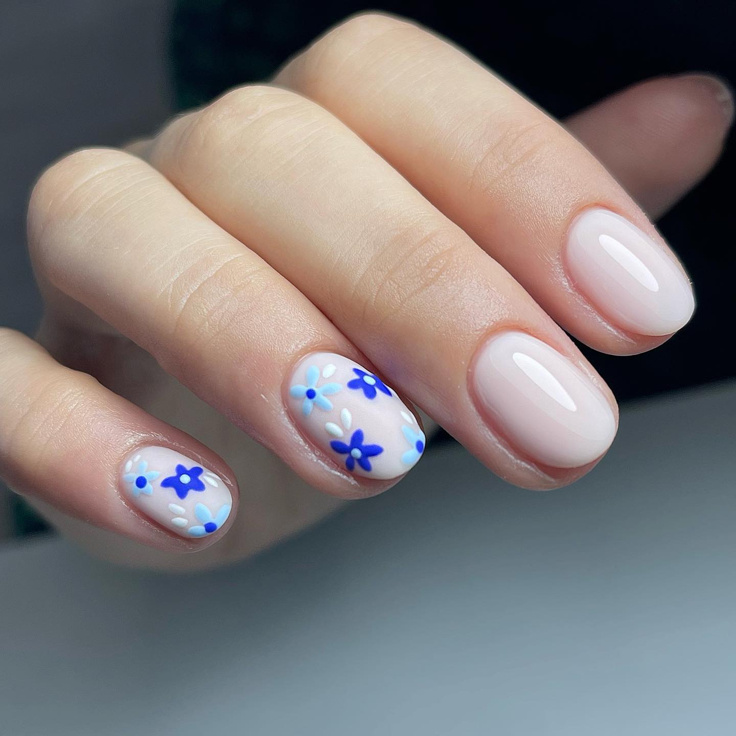 Short oval nails can be brighten up with floral accent nails. The color of nail polish, which is transparent white, is already an amazing one but you can use a matte nail polish for your accent nails. On top of them, you need to draw some bright and dark blue flowers to look cuter.