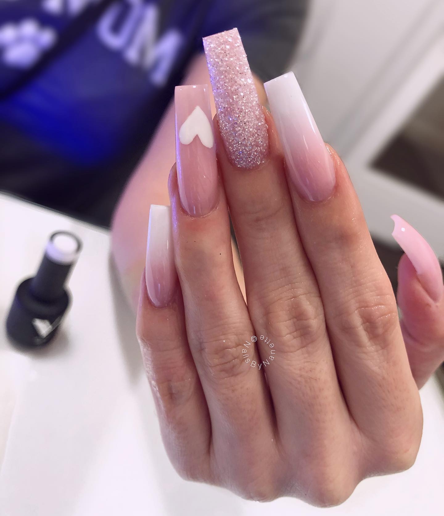 Let's show how adorable you are with long square pink and white ombre nails that are decorated with a heart nail art and glitters. The pink nail polish is on the foreground, so you will feel the cuteness of pink to a great extent.