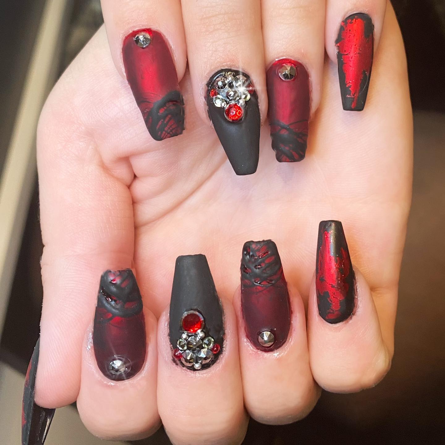 Are you ready to be gothic? Especially for special occassions like Halloween, this nail design is perfect. The matte black and red nails offer a gothic look with shiny stones on them. Let's feel Gothicism to its fullest.