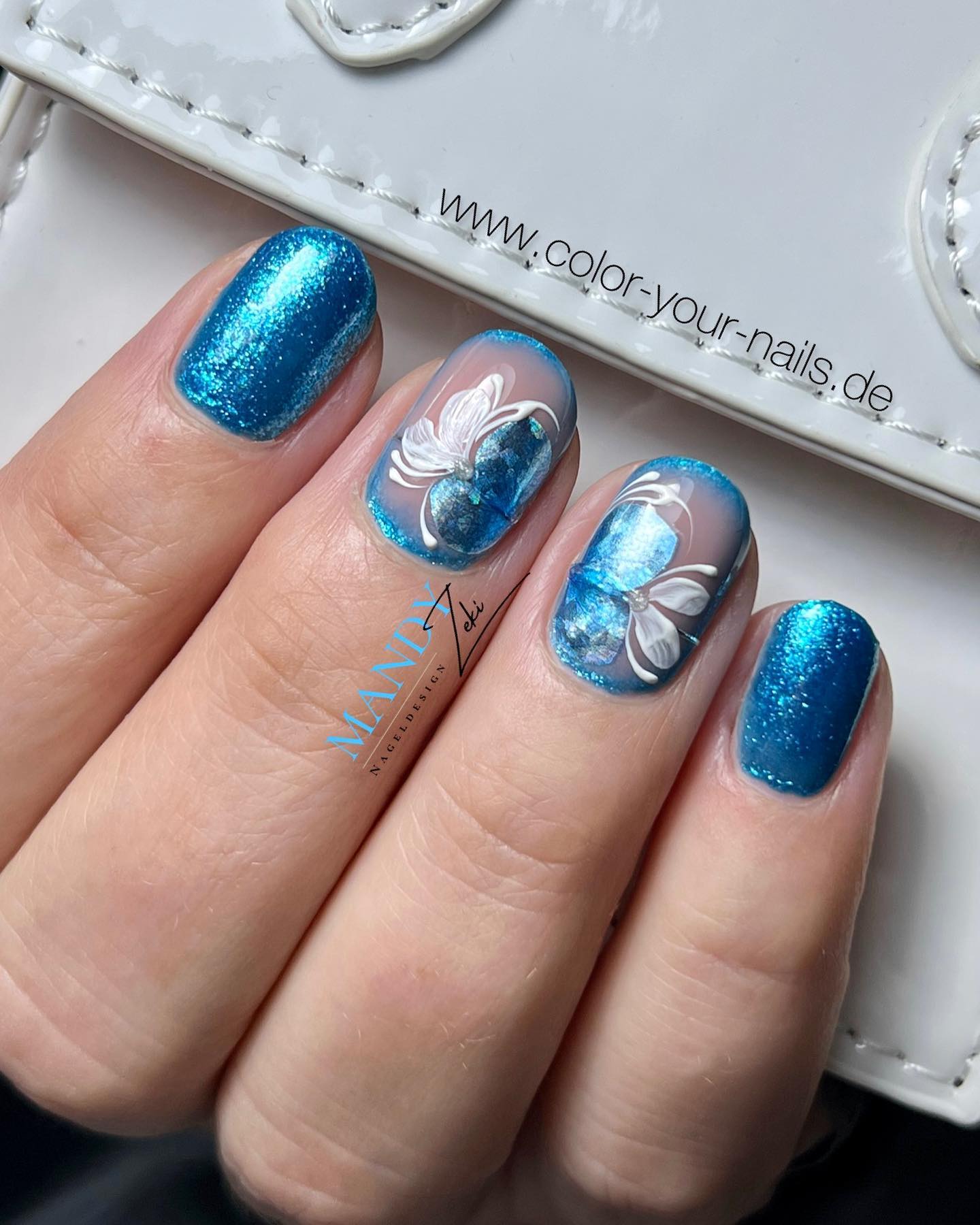 Las uñas con brillantina azul siempre están ahí para que brilles como un diamante.  Para llevar estas uñas a un nivel diferente, aplicar un arte de uñas floral para uñas decorativas suena increíble, ¿no?