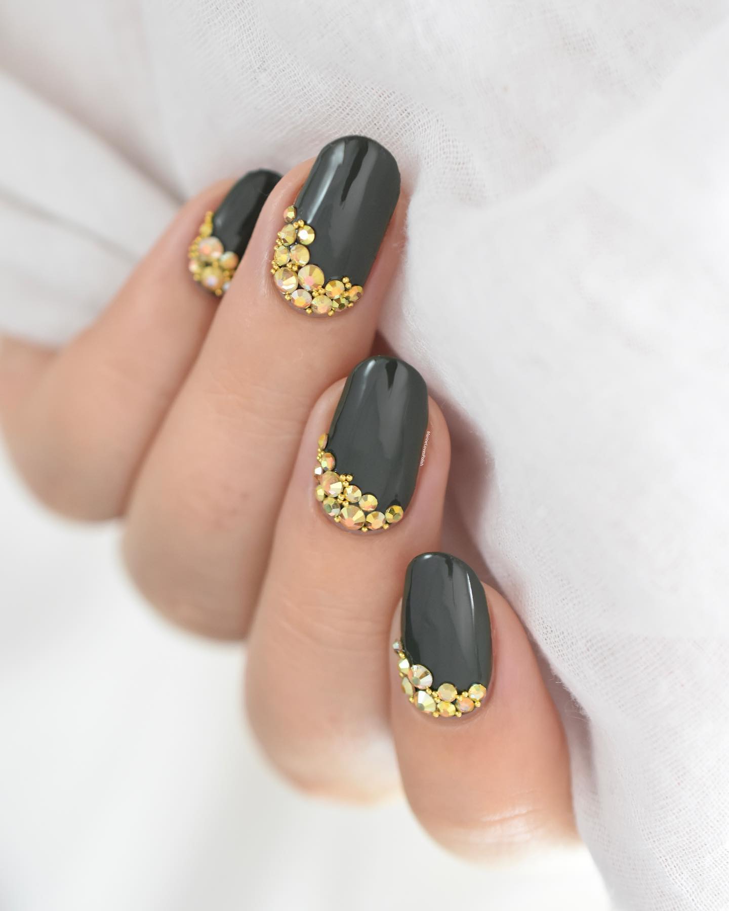 Loden green nails are a combination of the color grey and green. They're a lighter shade than dark green, but they have a tinge of gray to them. To make them shinier, all you need to do is to add some golden stones on top them.
