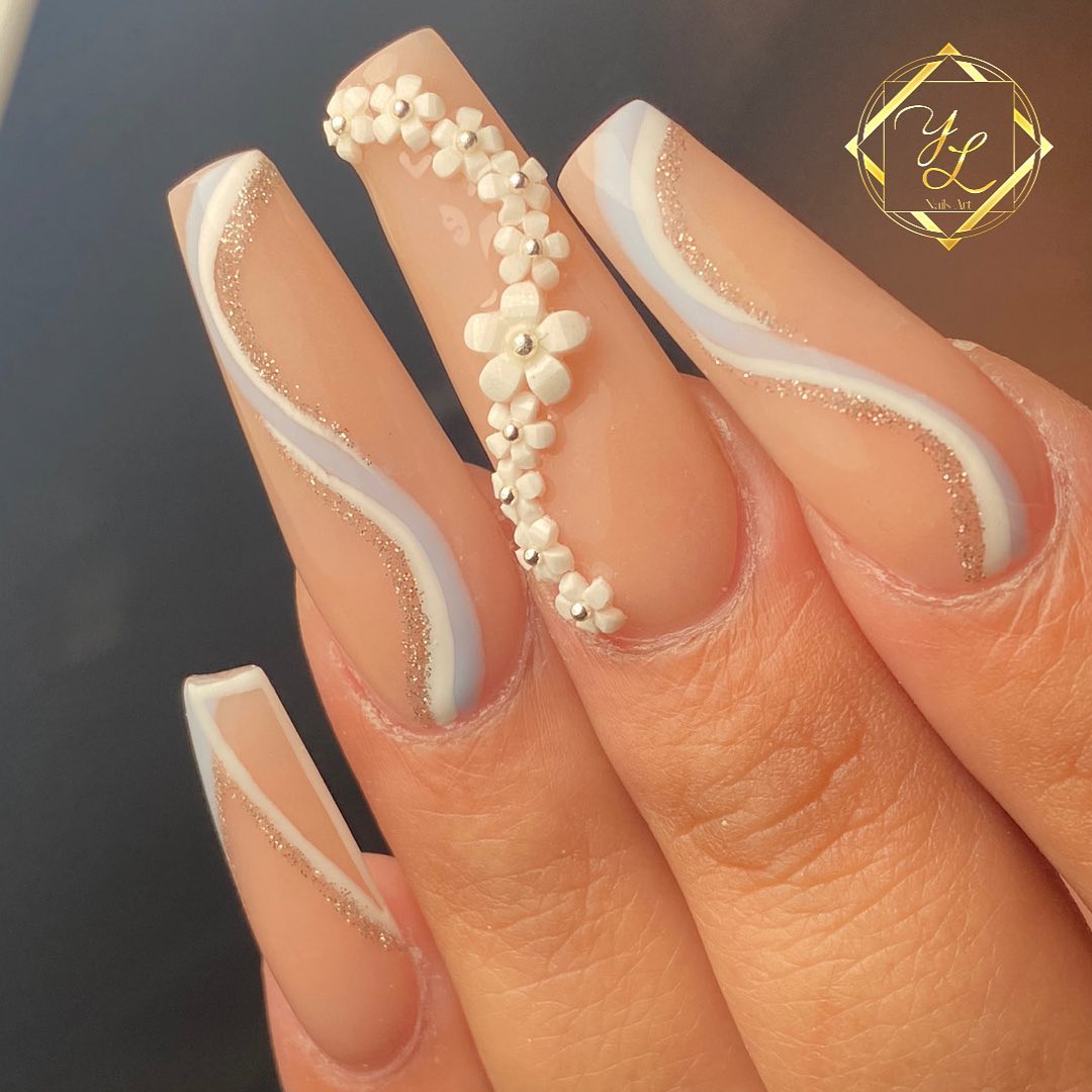 Here is an another nail design which is full of swirls. Long square acrylic nails express your personality but let's add more of your personality with some nail art. Colored swirls are all you need as well as flower stickers.