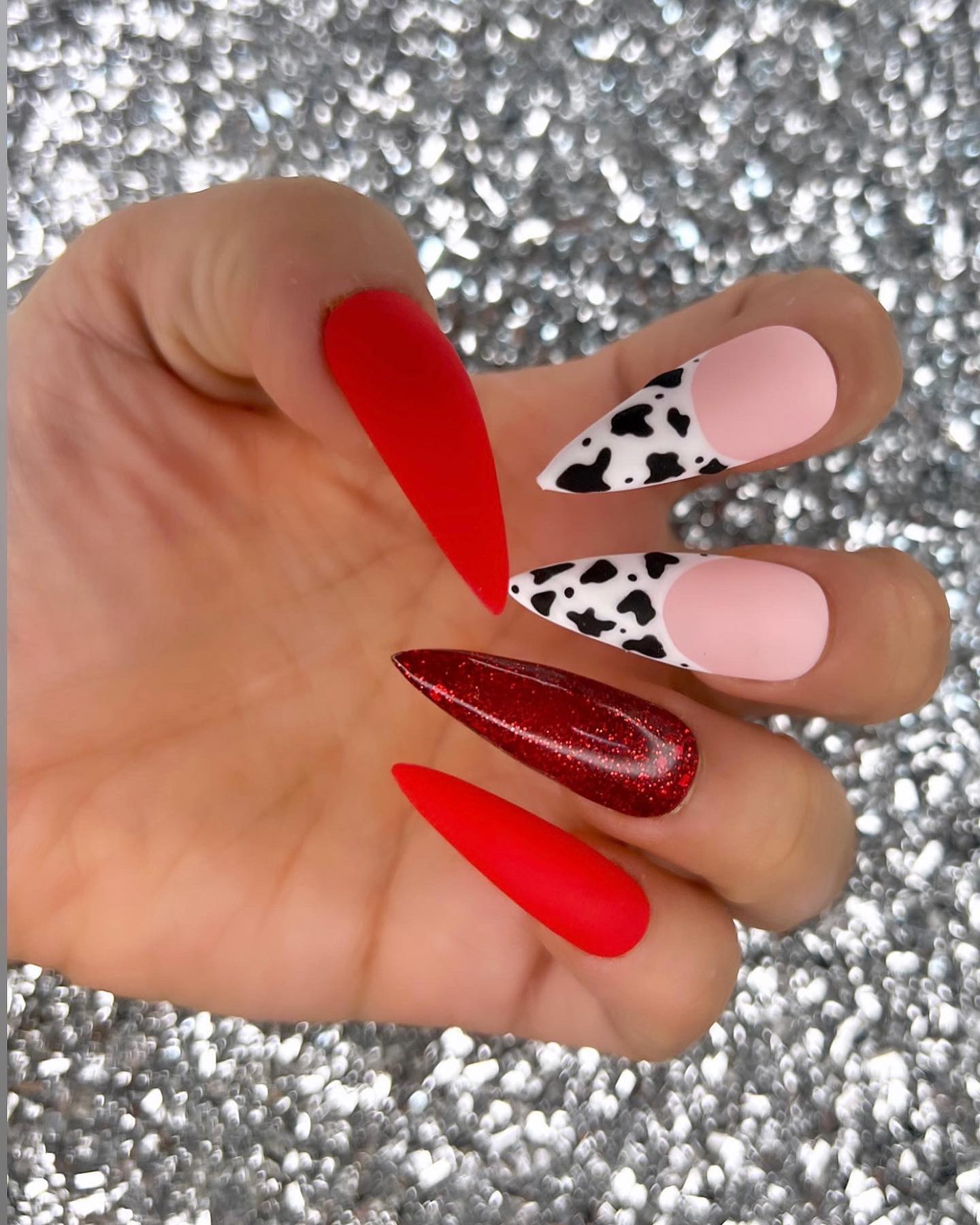 Red matte cow print nails are the perfect way to add a little something extra to your look. It's the perfect combination of fun and classy with glittered red nail polish and French cow print nail art!